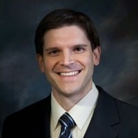man in a suit and tie smiling at the camera